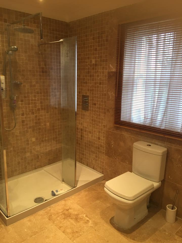 Walk-in shower and WC in a fully fitted travertine bathroom